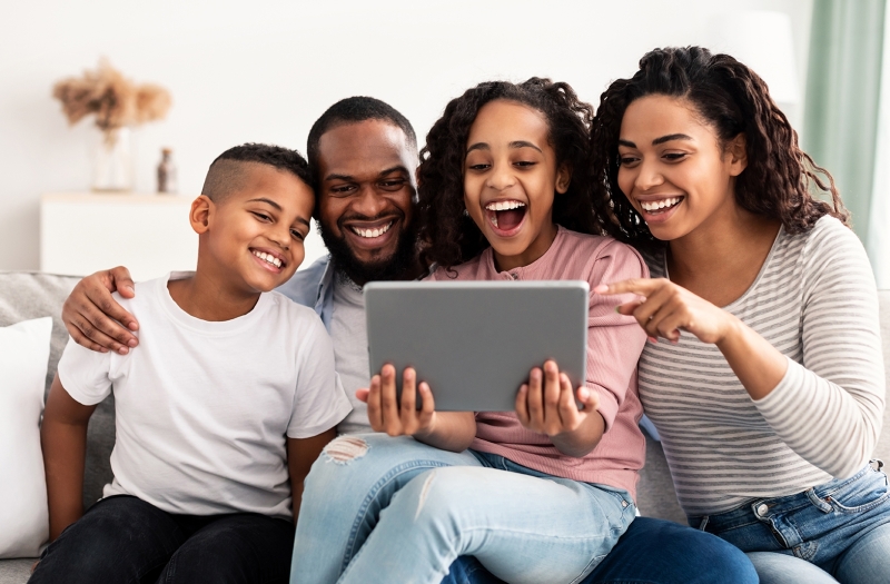 Happy family holding and using digital tablet computer