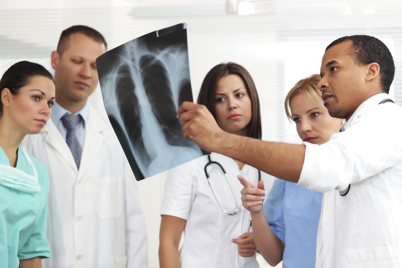 Doctors and nurses looking at patients x-ray.